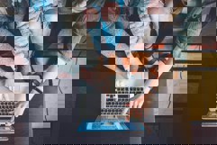 Group of people working together looking at laptop screen